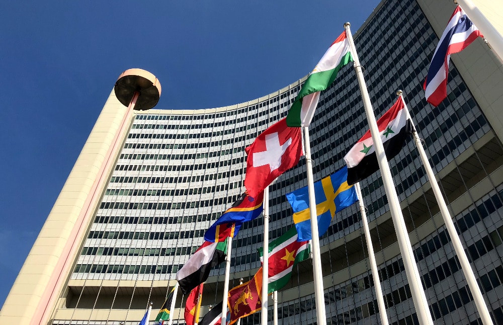 Gebäude der IAEA in Wien mit Länderflaggen im Vordergrund